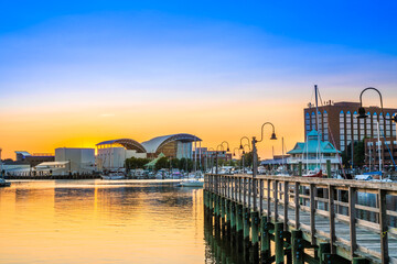 View of Hampton Virginia downtown waterfront district seen at sunset under colorful sky - obrazy, fototapety, plakaty
