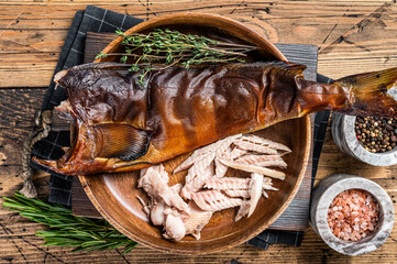 Fillet of Hot smoked fish pike perch or zander in a wooden plate with herbs. wooden background. Top...