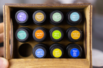 aroma oil concept. Top view essential oils in a bottle with black cap multicolored stickers named...