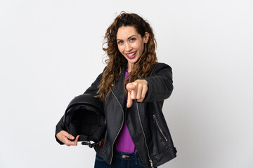 Obraz premium Young caucasian woman holding a motorcycle helmet surprised and pointing front