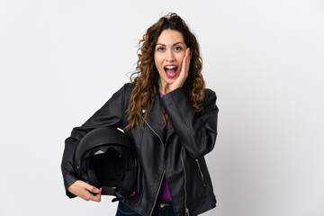 Young caucasian woman holding a motorcycle helmet with surprise and shocked facial expression