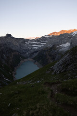 Epic Sunset over an alpine lake called Limmerensee in Switzerland. Wonderful scenery in the alps. The sun shines to the peaks of the mountains. Just amazing.