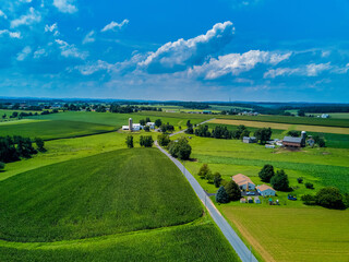 Amish farms dot the landscape as fresh corn and other vegetables grow organically as seen from an aerial drone image