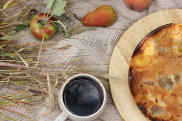 A cup of tea and a pie with apples. View from above