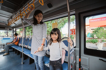 mother and daughter going to school in the morning by public bus