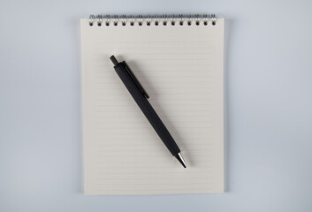 Notebook and black pen, white background.