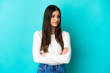Young caucasian woman isolated on blue background looking to the side