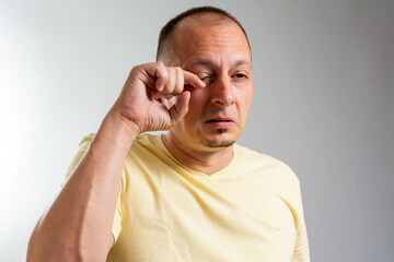 close up man using hand to rubbing eyes after feeling itchy for conjunctivitis healthcare concept....
