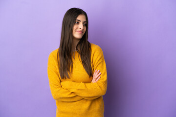 Young caucasian woman isolated on purple background looking to the side