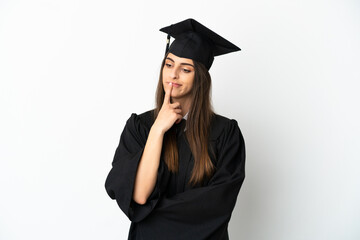 Young university graduate isolated on white background having doubts while looking up