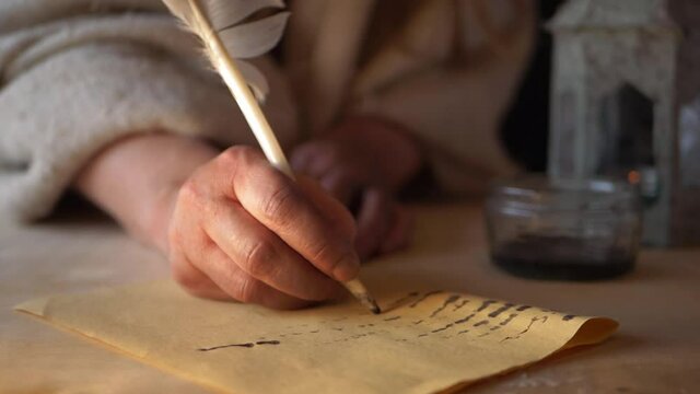 Writing a letter in with feather quill in historical scene