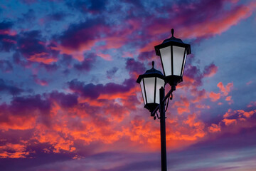 Fototapeta na wymiar Vintage streetlight against the sky background. Sun rays creating an unusual sky