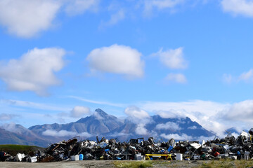 Mounds of discarded scrap metal stand in stark contrast to the natural mountain landscape at an...