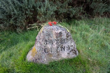 Culloden battlefield in Scotland. Isolated headstone for Mixed Clans with background of grass and other greenery.