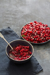 Lingonberries in a plate on a dark textured background and lingonberry jam.