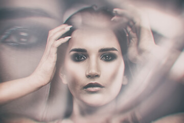 Portrait of a beautiful elegant girl with smokey eye makeup. Face close-up.  Double exposure.