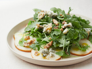 close-up view of rocket salad dish with pear, blue cheese and walnuts