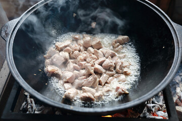 Cooking meat in cauldron on fire in gazebo