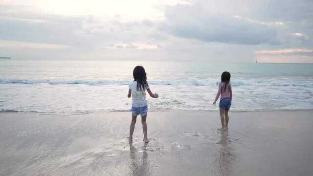 girls have fun and joy time at beautiful beach while running from joy