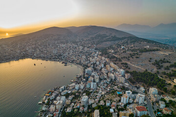 Aerial sunset drone view of Saranda city and port in Albania.