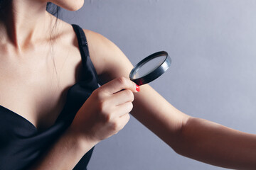 Fototapeta premium woman looking at her hand with a magnifying glass