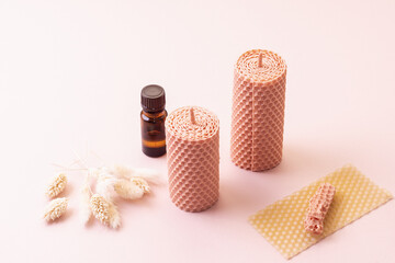 Natural candles made of wax and aromatic oil on pink background