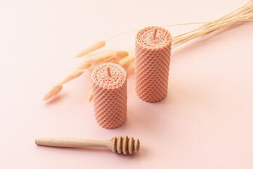 Decorative candles made of beeswax on pink background. Natural eco product