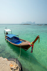Obraz premium Long-tail boat moored to port on a sunny day with turquoise waters