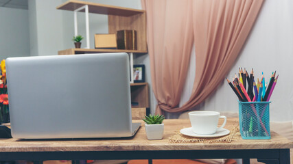 Fototapeta premium Desk for student concept. Desktop Laptop for study for exam, Computer, headphone, pencils, cactus, and cup of coffee place on School table for student work online at home.