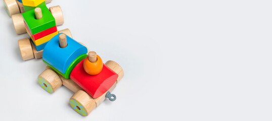Wooden train with colored blocks on white background. Kids toys made of natural wood in rainbow colors. Eco friendly toy, game, plastic free. Toy for babies and toddlers. Flat lay