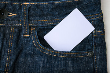 A white blank card in a dark blue jeans pocket for text, copy space