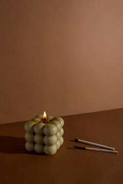 Aromatic scented soy candle with smoke on beige brown textile background , modern bubble candle still life