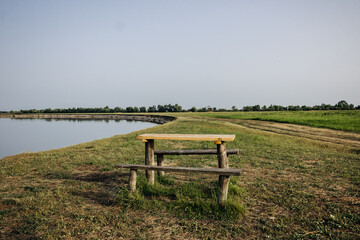 Beautiful summer landscape by the river. Wooden table and benches by the river. Pripyat river, Belarus