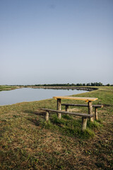 Beautiful summer landscape by the river. Wooden table and benches by the river. Pripyat river, Belarus