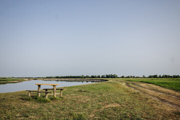 Beautiful summer landscape by the river. Wooden table and benches by the river. Pripyat river, Belarus