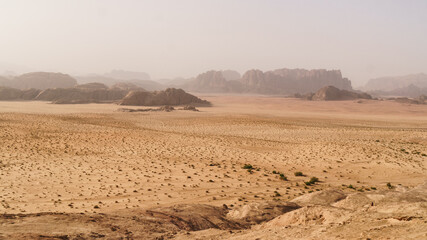 Fototapeta na wymiar Wadi Rum desert, Jordan. Designation as a UNESCO World Heritage Site. National park outdoors landscape. Offroad adventures travel background. Haze wheather.