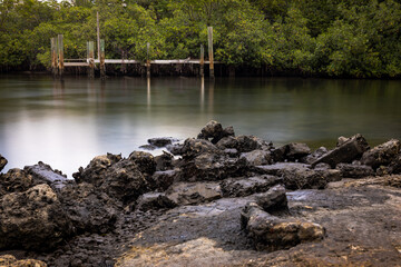 long exposure dock with rocks in the foreground.  © Joe Ciciless