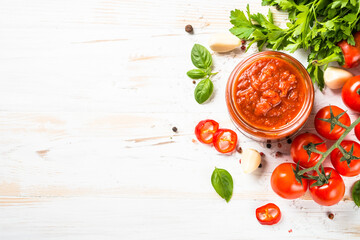 Tomato sauce. Traditional italian tomato sauce with herbs and spices at white kitchen table. Top view with copy space. - obrazy, fototapety, plakaty