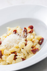 potato dumplings called halusky with dry tomatoes and grated cheese