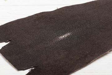 brown grey natural colored rays leather on the wooden table	