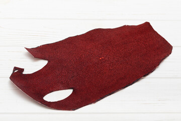Red natural  colored rays leather on the wooden table