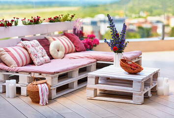 cute, cozy pallet furniture with colorful pillows at summer patio, lounge outdoor space - 457002904