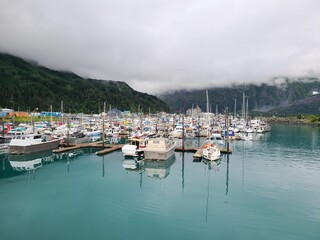 Fototapeta na wymiar boats in harbor in Alaskan port with hazy cloud cover