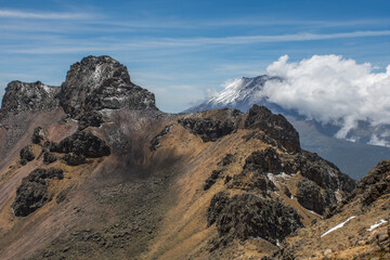 Volcano behind the mountain with snow