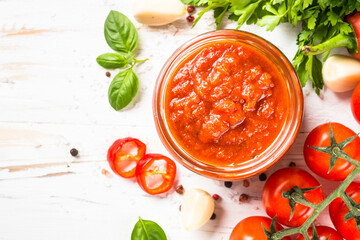 Tomato sauce. Traditional italian tomato sauce with herbs and spices at white kitchen table. Top view with copy space.
