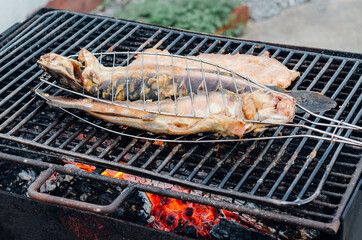 Grilling fishes with flames from charcoals.