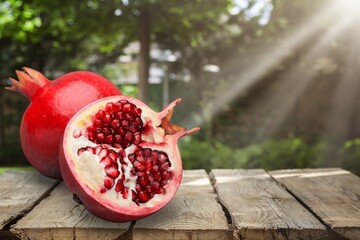 Red fresh ripe pomegranates on a table, the concept of the Jewish new year - Rosh Hashanah.