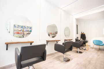 Modern bright beauty salon. Hair salon interior business with black chairs, round mirrors and neon...