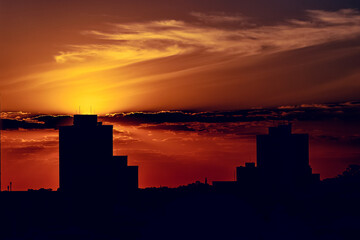 Fototapeta premium Silhueta da paisagem urbana de São Carlos São Paulo com o céu colorido de laranja e amarelo devido ao por do Sol