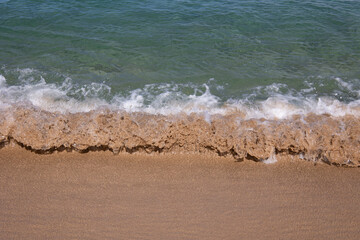 Close up of small wave on sand in tropical beach. Ocean water background 